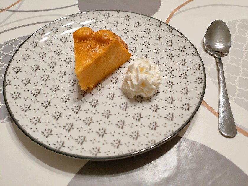 part de flan sucré à la citrouille servie avec de la chantilly