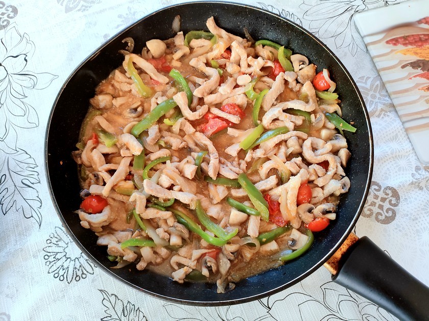 émincé de porc aux légumes dans une grande poêle.